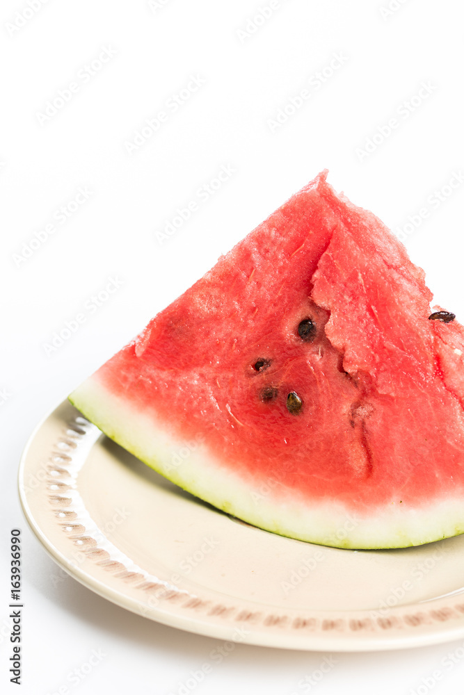 Triangle slice of watermelon on the plate isolated over white background Triangle slice of watermelon on the plate isolated over white background