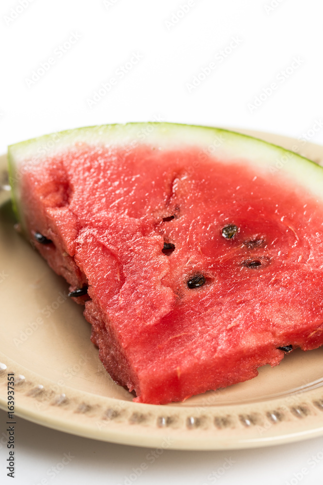 Triangle slice of watermelon on the plate isolated over white background Triangle slice of watermelon on the plate isolated over white background