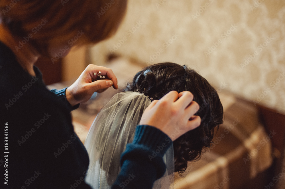 Naklejka premium The bride is wearing a veil. Beautiful long veil of white color