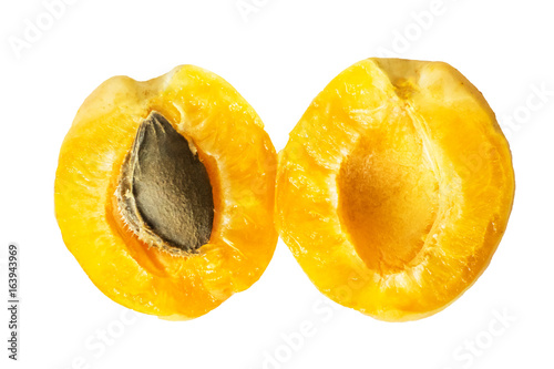 Two halves of a juicy ripe pineapple apricot with a bone inside. Isolated halved fruit on a white background. Top view.