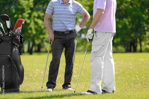 Young men on golf course in sunny day