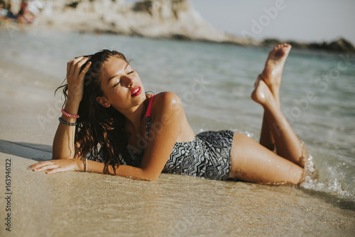 Pretty young woman lying on the beach