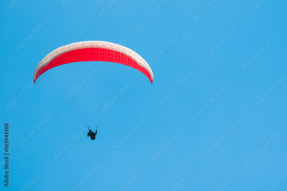 Paraglider flies paraglider in the sky. Paragliding. Paraglider flies paraglider in the sky. Paragliding.