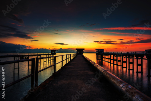 The sun reflected off the bridge that stretches into the sea.In Chonburi Thailand. © MAGNIFIER