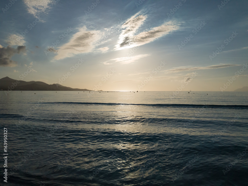 Obraz premium Sunrise sun light through clouds and sunlight reflections on sea water. European island Mallorca