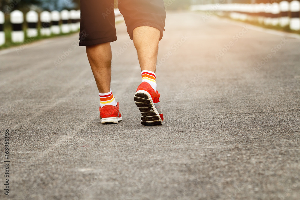 Young and fitness runner man running on road