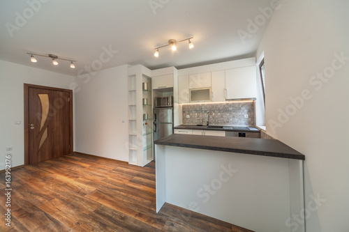 New modern white kitchen. New home. Interior photography. Wooden floor.