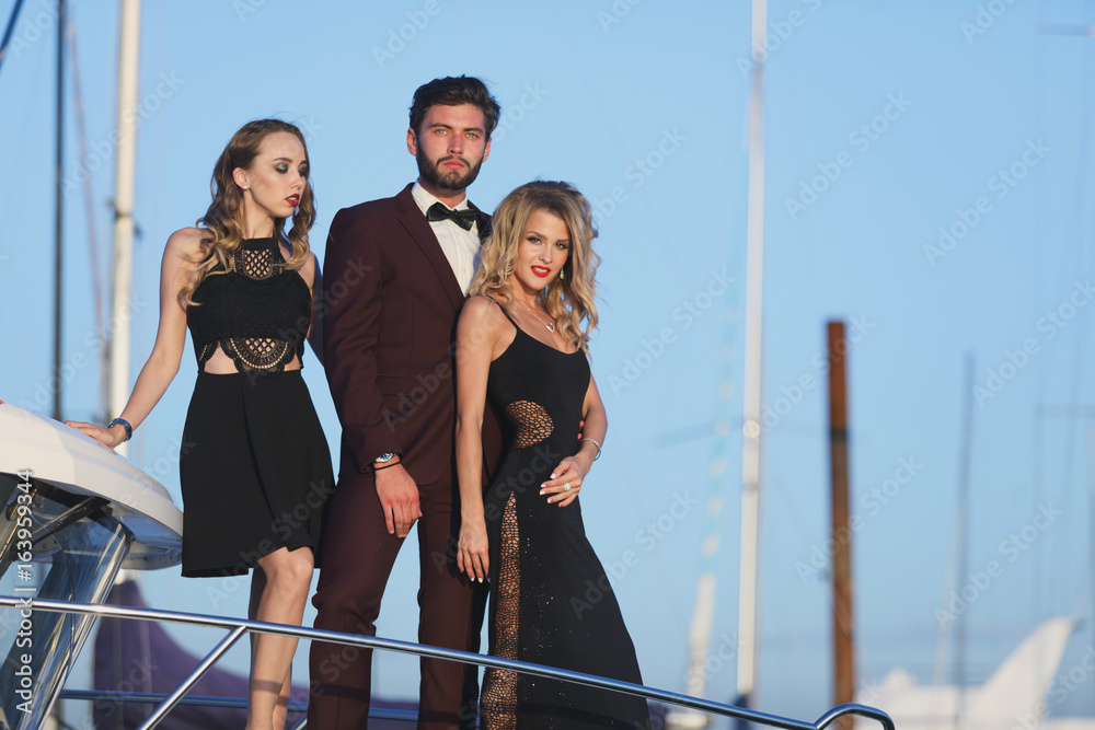 Obraz premium Group Of Young Friends Relaxing On A Boat Enjoying Sunny Day