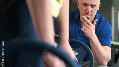 Girl is engaged in sports with the trainer photo