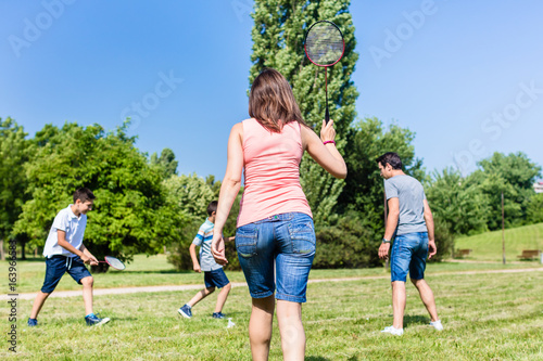 Mother and son playing badminton in park in summer