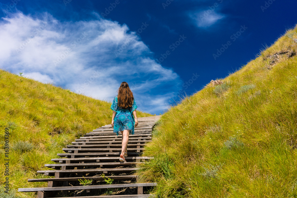 Naklejka premium Young woman climbing stairs outdoors in an idyllic travel destination from Indonesia