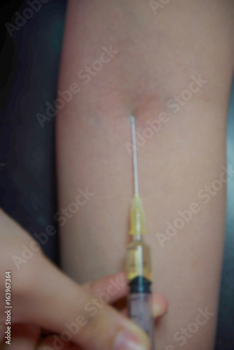 Background blur addiction is using a syringe.