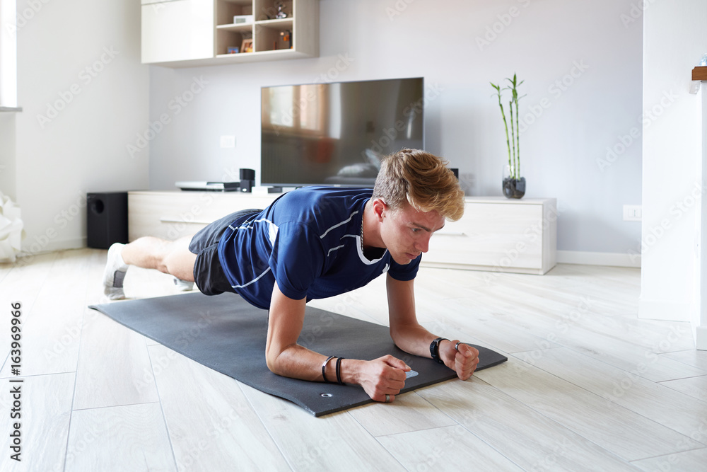 Ragazzo fitness a casa con app plank