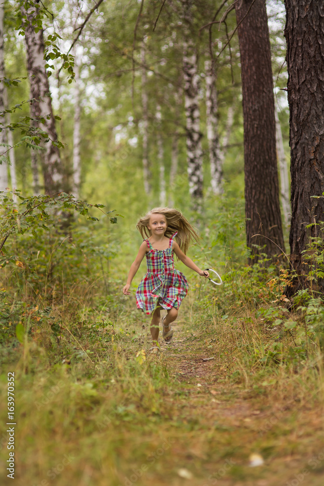 Little girl playing, running and enjoying in the forest