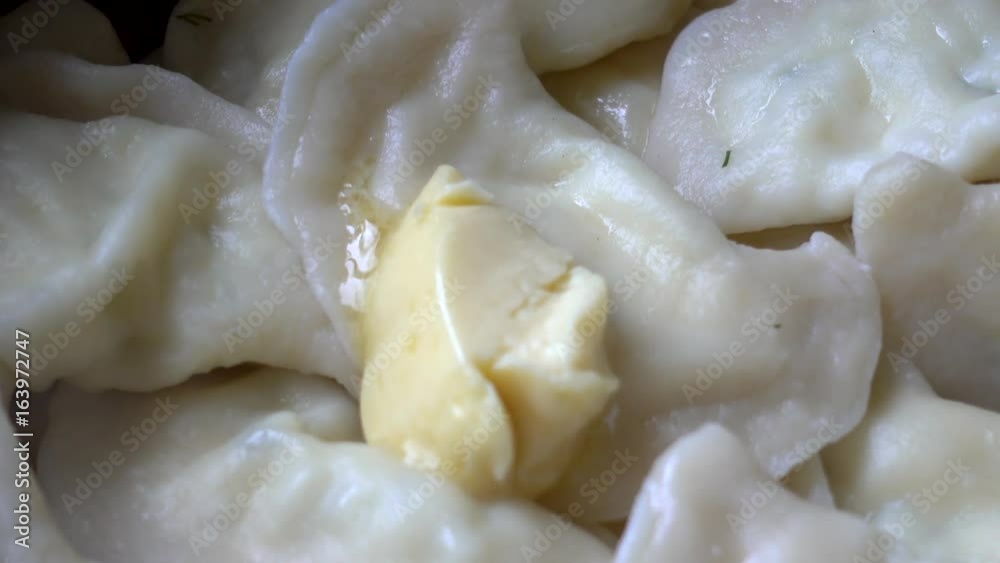 Boiled homemade dumplings in a metal bowl. A piece of butter melts on hot dumplings or vareniks. Close up fhd footage Boiled homemade dumplings in a metal bowl. A piece of butter melts on hot dumplings or vareniks. Close up fhd footage