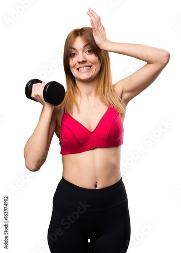 Beautiful sport woman with dumbbells having doubts