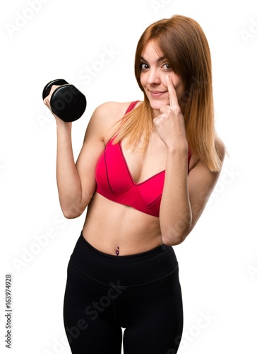 Beautiful sport woman with dumbbells showing something
