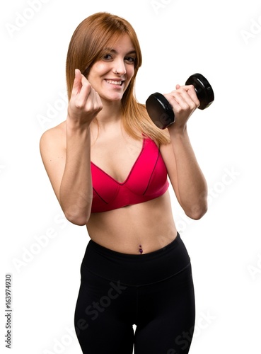 Beautiful sport woman with dumbbells making money gesture