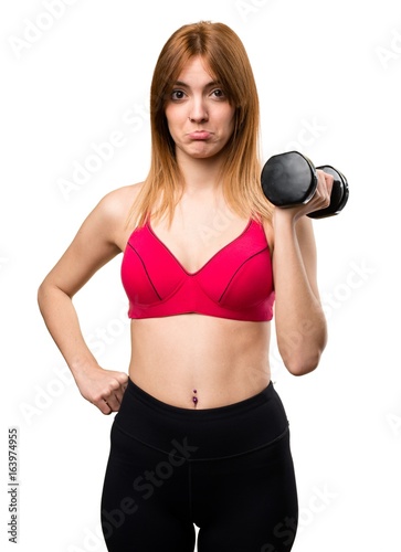 Sad beautiful sport woman with dumbbells
