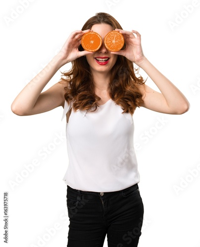 Beautiful young girl wearing orange slices as glasses