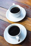 two cup of hot black coffee,  place on old wood background.