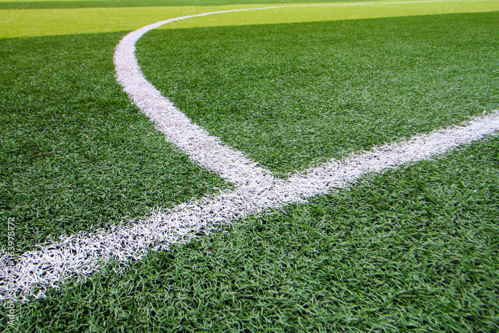 Photo of a green synthetic grass sports field with white line shot from above