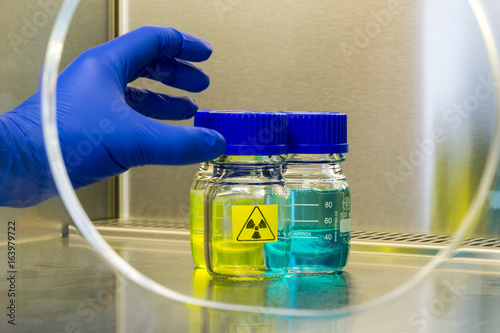 hand grabs a radioactive sample in a laboratoy environment