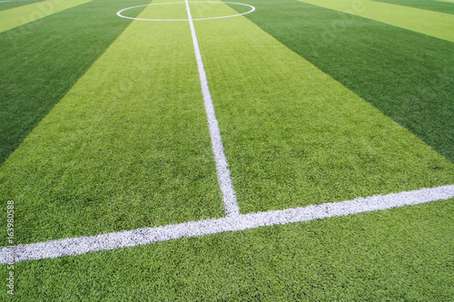 Photo of a green synthetic grass sports field with white line shot from above © Fotoglee