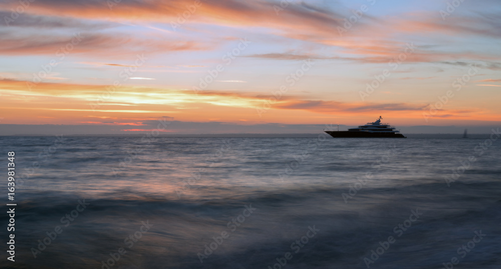 Luxury 'Super Yacht' moored up against a romantic vibrant sunset Luxury 'Super Yacht' moored up against a romantic vibrant sunset
