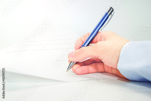 Man hand signing document 