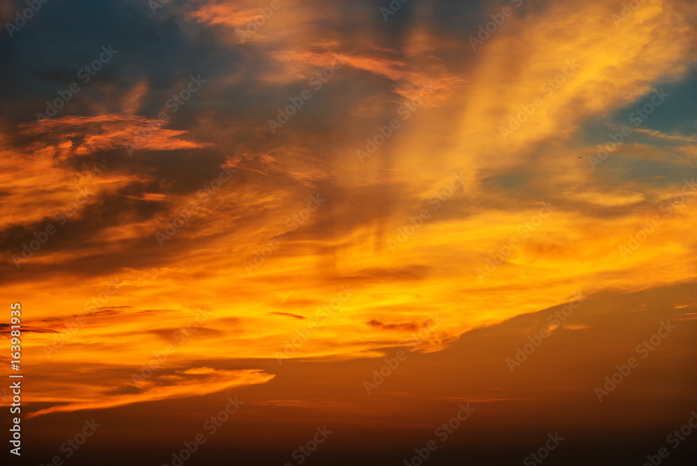 Obraz premium Zachód słońca sprawia, że niebo i chmura stają się pięknym złotym kolorem żółtym.