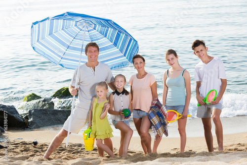Family standing on sandy beach