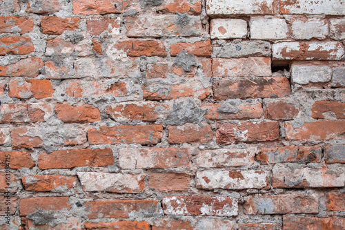 Old brick wrecked wall biege grunge surface weathered concrete cement with holes, erosion and destruction. Texture, background