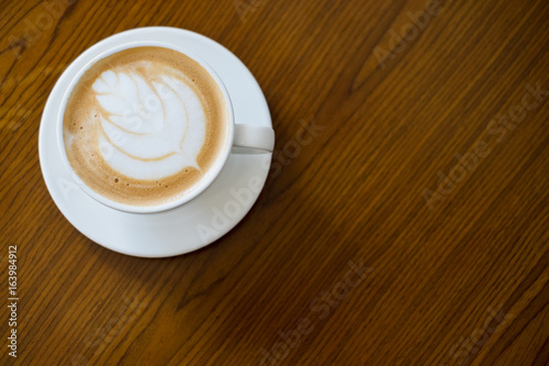 Latte art coffee on wooden table