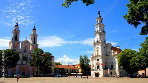 Rathausplatz mit altem Rathaus und Jesuiten-Kathedrale vor blauem Himmel in Kaunas