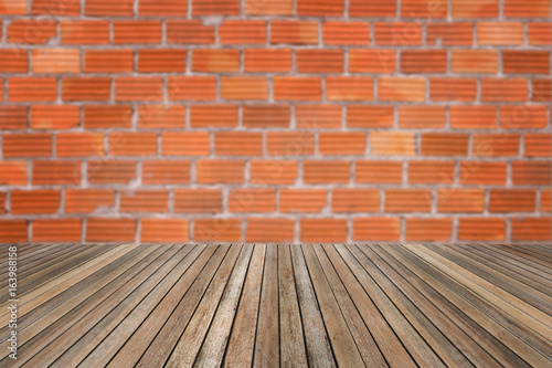 Wooden table on brick wall background