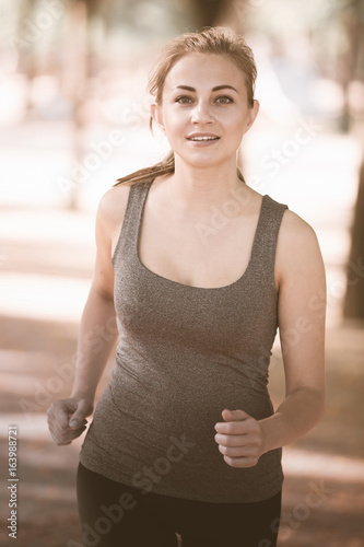 happy female in sportwear running in the sunny park Free Download happy female in sportwear running in the sunny park - GFXLoad