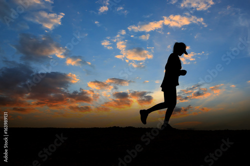 Running woman silhouette in sunset time