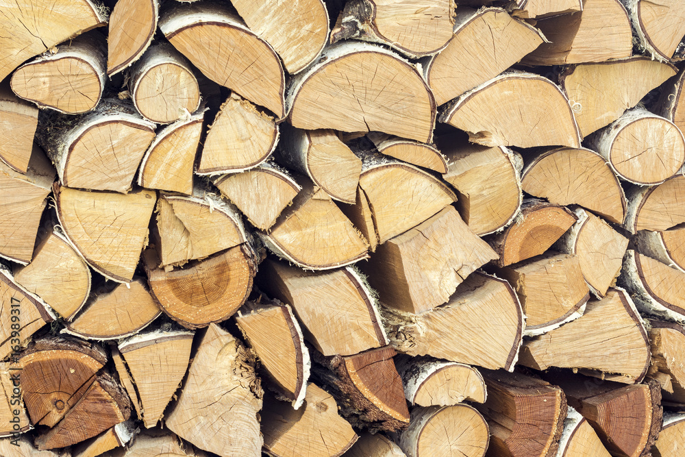 Natural wooden background, closeup of chopped firewood, logs.  Chopped firewood on a stack