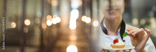 Fotografia Chef holding dessert tart with elegant blurry lights transition
