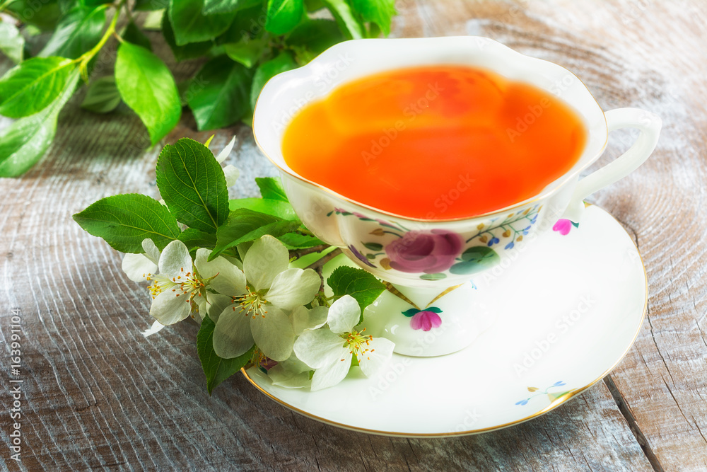Tea cup on wooden table and apple blossom Tea cup on wooden table and apple blossom