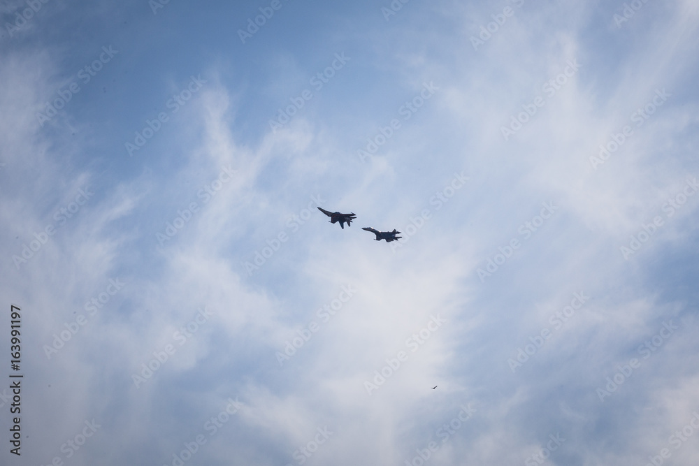 Group of two pilots make aerobatics figure on su-27 fighter in the sky at air show