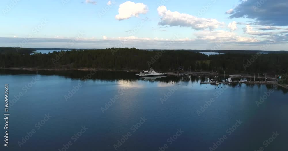 Mossala ferry, Cinema 4k aerial view towards a white ferry, docked at a terminal, heading to inio, on a sunny summer evening, in houtskari, in the finnish archipelago of Turku Mossala ferry, Cinema 4k aerial view towards a white ferry, docked at a terminal, heading to inio, on a sunny summer evening, in houtskari, in the finnish archipelago of Turku
