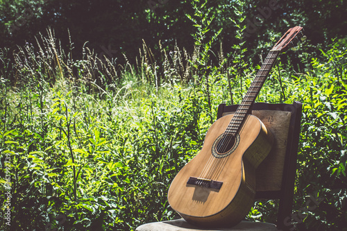 Guitar on a chair outside in grass