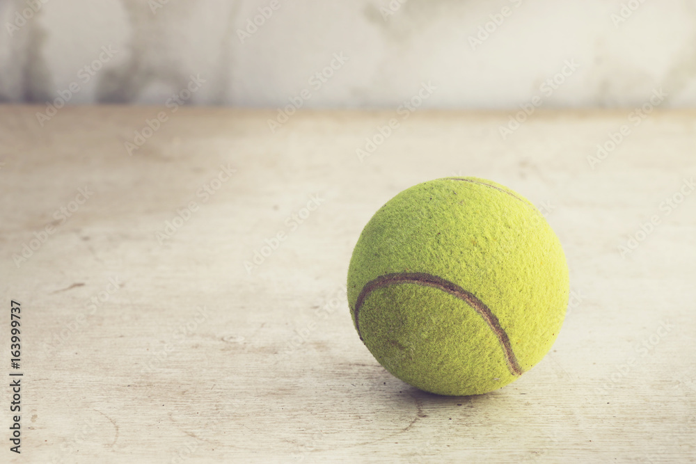 Tennis ball on wooden floor