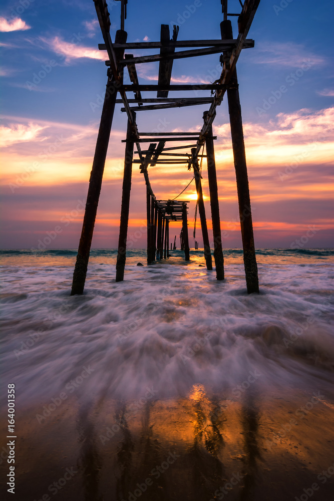 Sky and clouds and a light evening twilight. The old wooden bridge on the sea Waves and beaches in Thailand.