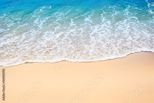 light wave of sea on the sandy beach in summer time