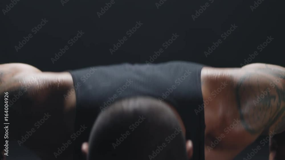 Close up shot of muscular black man doing some push ups and taking a break