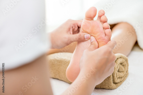 Foto Therapist giving traditional thai foot massage to a woman