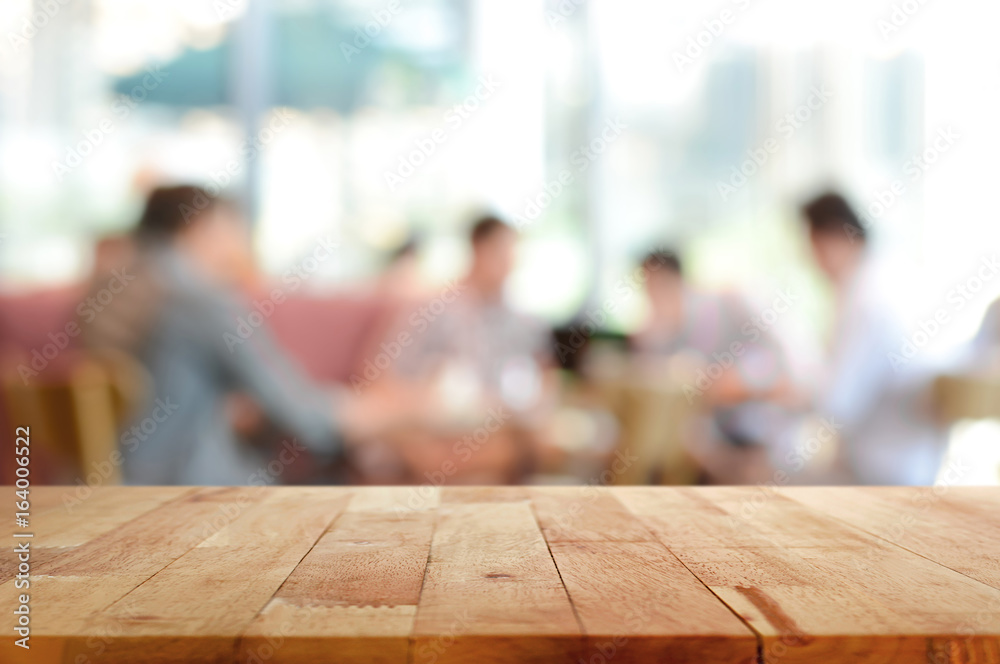 Wood table top with blurred people in cafe as background
